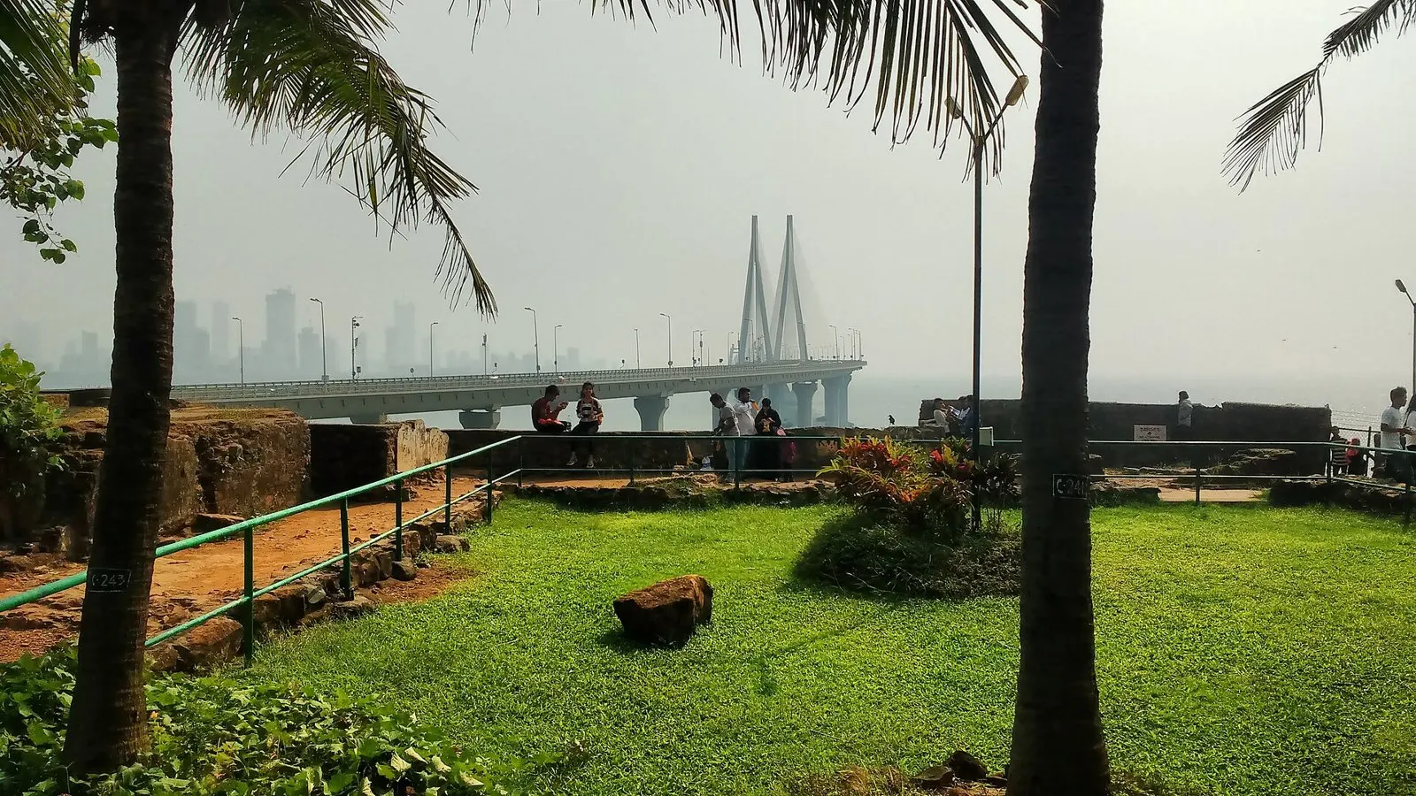 Lawns and palms on top of Bandra Fort, the Sea Link fading into haze beyond