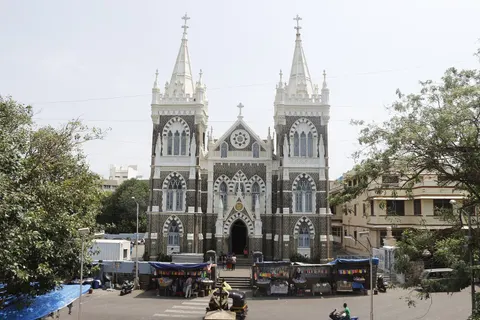 The twin-towered stone facade of Mount Mary Basilica above the street in Bandra