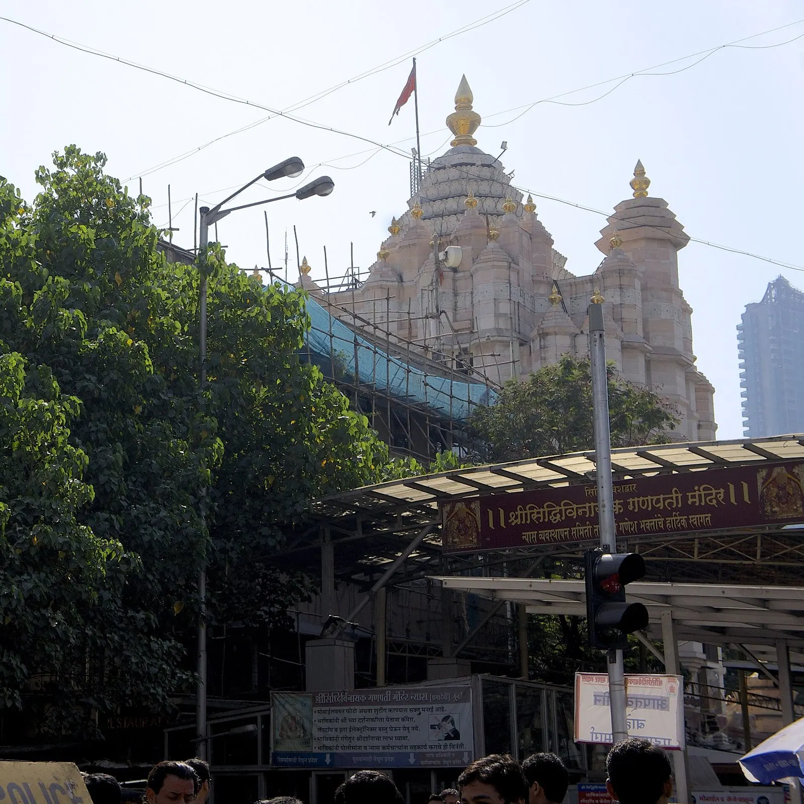 Siddhivinayak Temple’s towers behind trees and the covered entrance walkway