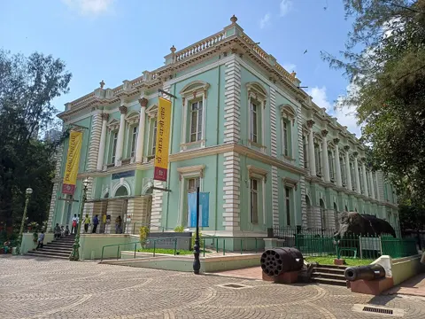 Mint-green façade of the Bhau Daji Lad Museum with old cannons on the forecourt