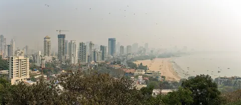 Chowpatty Beach and the curve of Marine Drive seen from the hill above, under a hazy sky