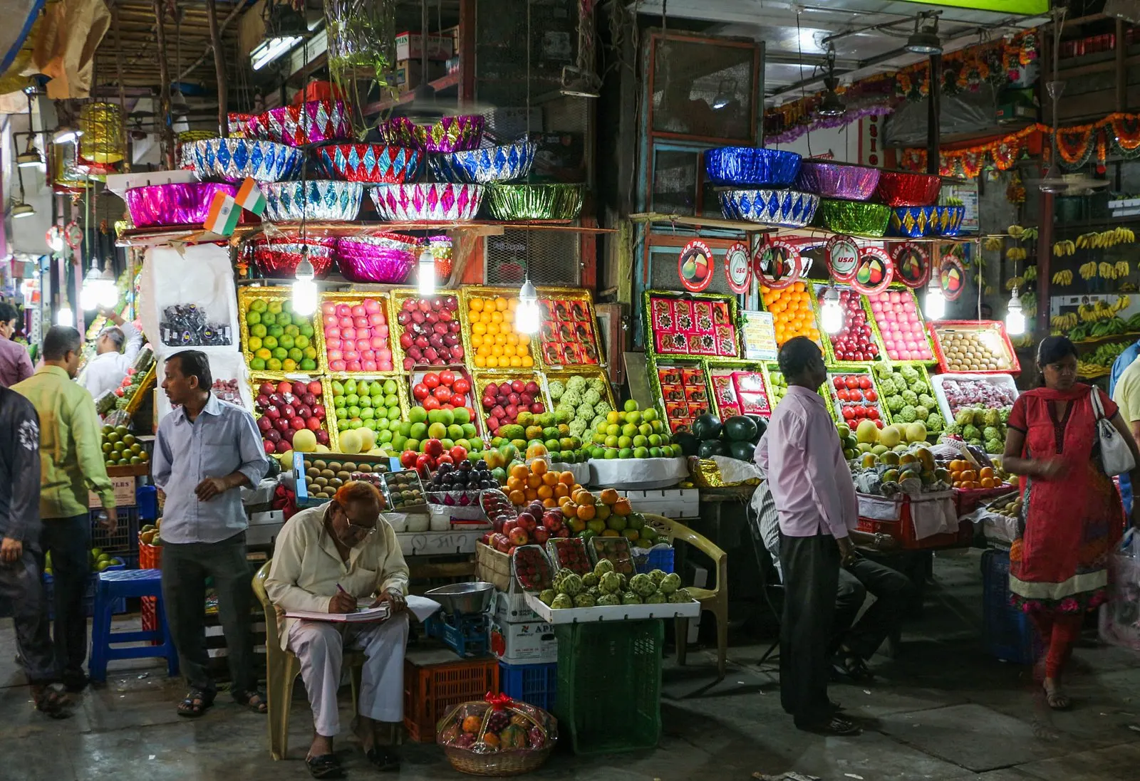 A fruit stall stacked with apples, pomegranates and oranges at Crawford Market